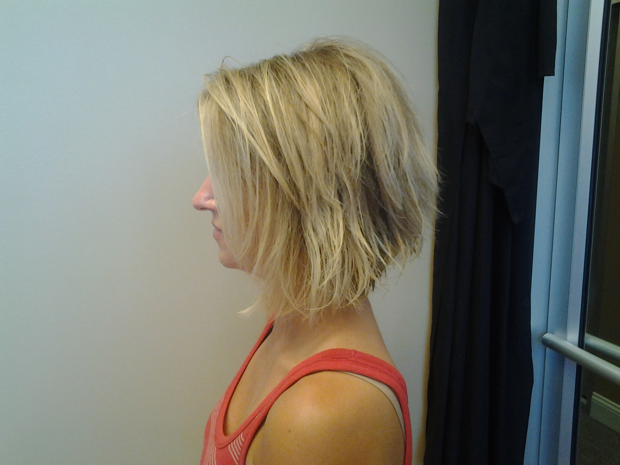 A textured, layered blonde bob seen from the side