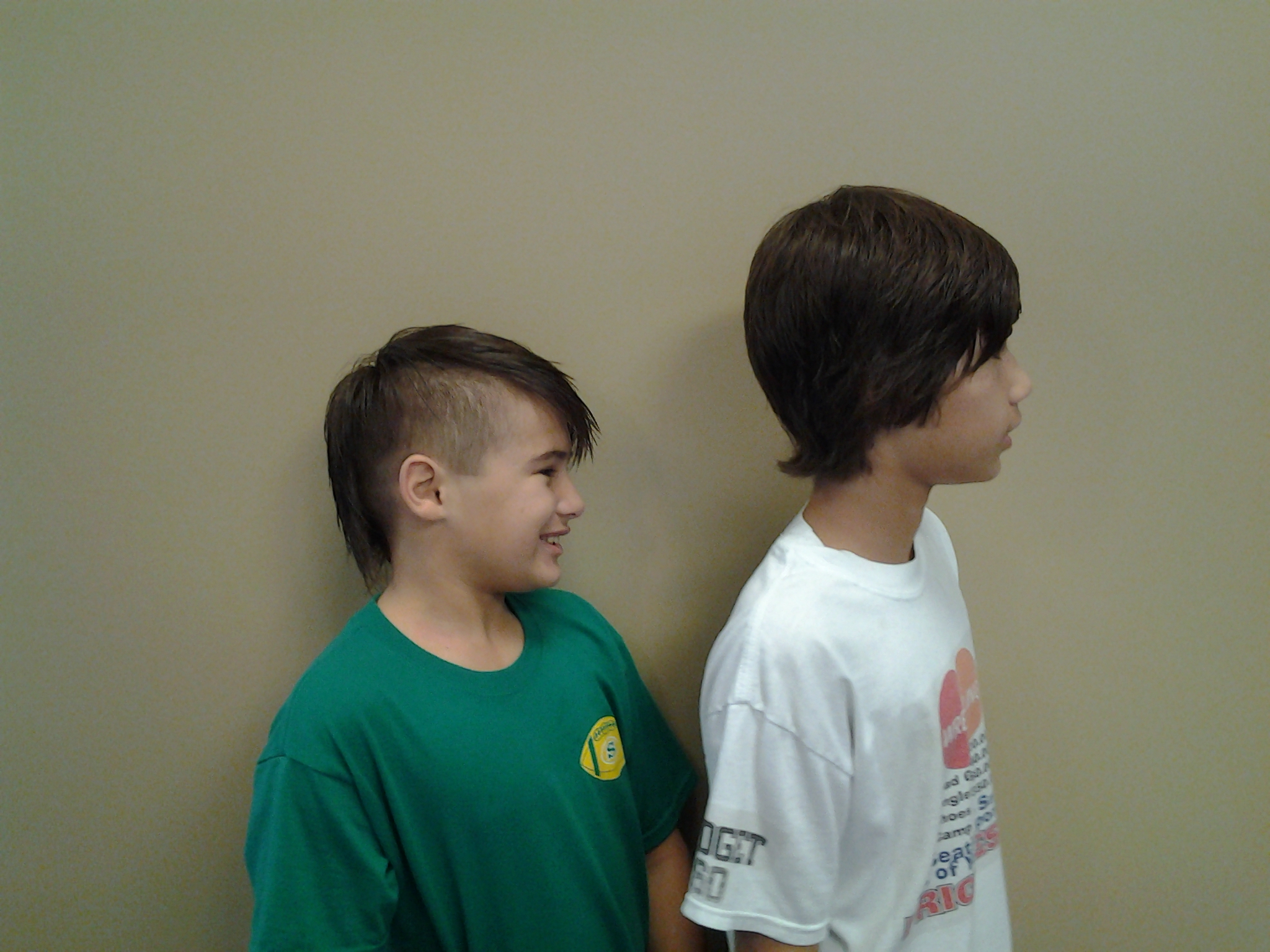 Two boys smiling after their haircuts